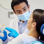 dentist explaining implant-supported dentures to patient